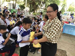 Cô Lê Thị Sơn Ân - Hiệu trưởng Trường THCS Phú Cường phát quà cho các em học sinh